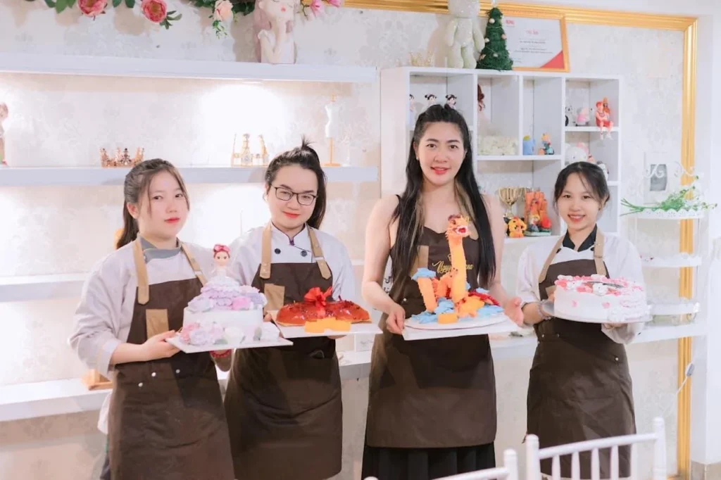 Học viên nữ cầm bánh kem tự làm tại Học viện Nguyên Anna